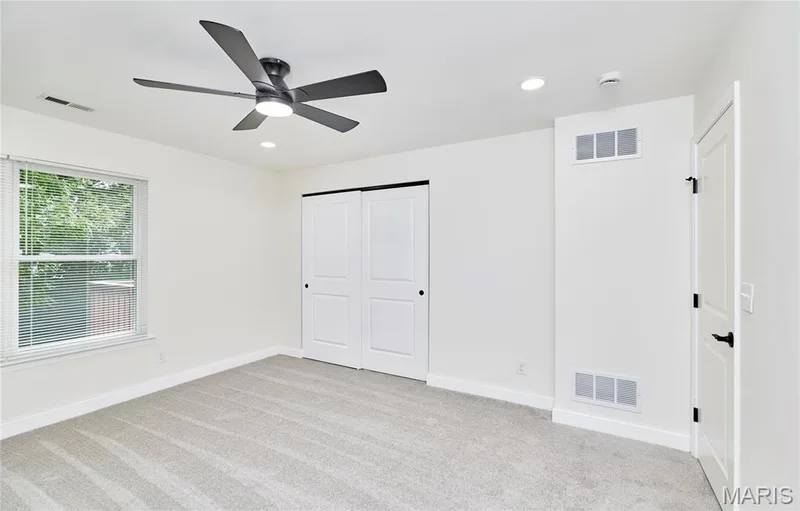 Light-toned carpeting, white walls, and a modern ceiling fan with integrated lighting — 214 Sugar Lake Drive #5, St Peters, MO 63376