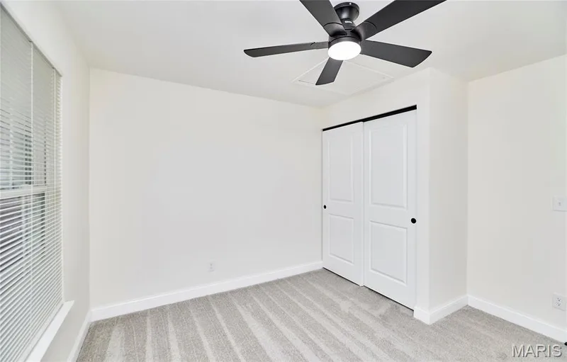 Bedroom featuring light gray patterned carpet, white walls, and white baseboards — 214 Sugar Lake Drive #5, St Peters, MO 63376