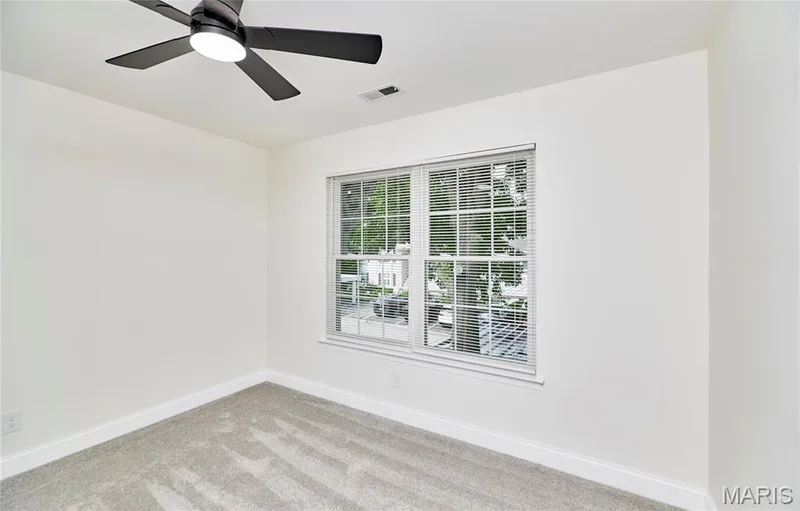 Bright bedroom featuring light-toned carpeting and white baseboards — 214 Sugar Lake Drive #5, St Peters, MO 63376