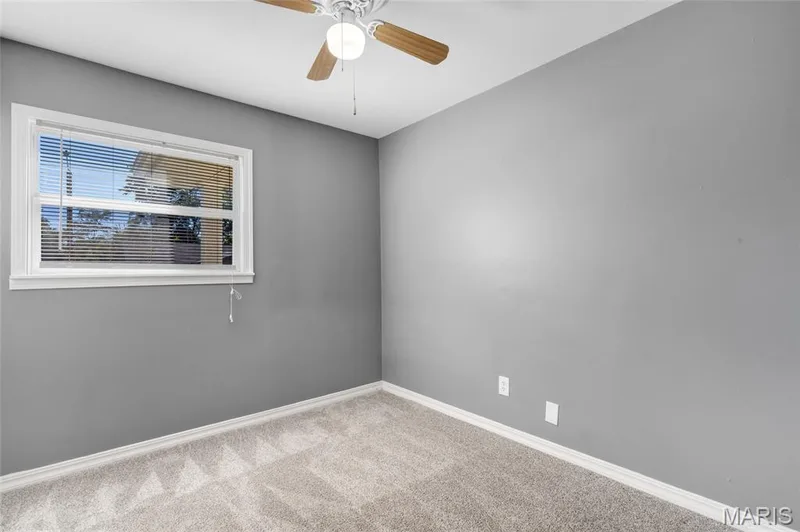 Room featuring neutral gray walls, wall-to-wall carpeting, and a ceiling fan with integrated lighting — 503 Eggering Drive, O'Fallon, MO 63366