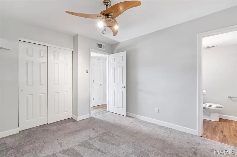Room featuring neutral wall tones, wall-to-wall carpeting, a three-blade ceiling fan with integrated lighting, and six-panel doors — 503 Eggering Drive, O'Fallon, MO 63366