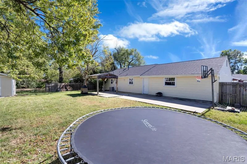 Spacious backyard featuring a concrete patio, wood-frame pergola, and mature trees — 503 Eggering Drive, O'Fallon, MO 63366