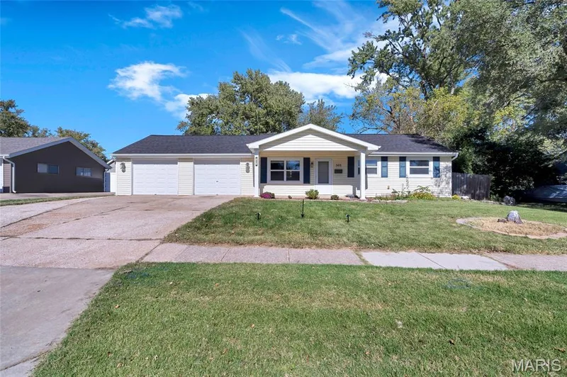 Ranch-style exterior featuring horizontal siding, a covered front entryway, attached two-car garage, and dark-toned roof shingles — 503 Eggering Drive, O'Fallon, MO 63366
