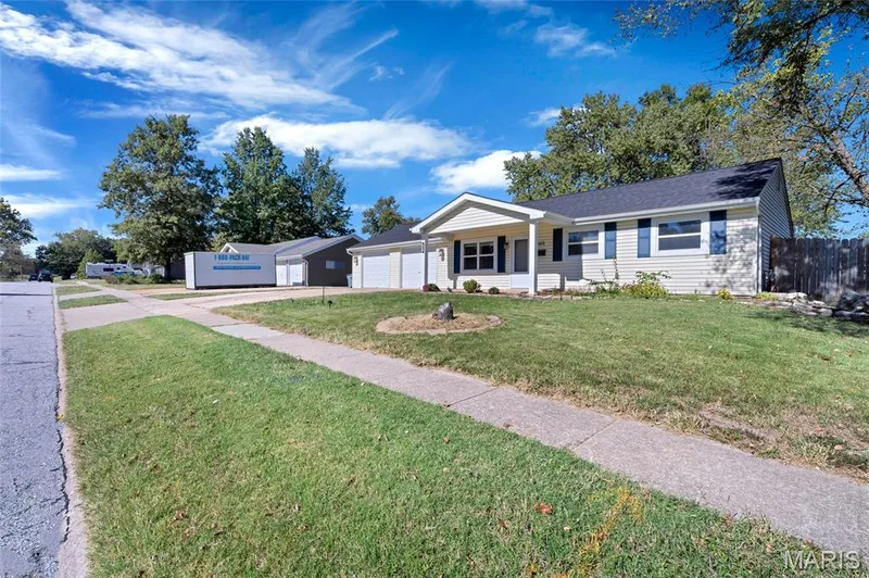 Single-story residence featuring light-colored horizontal siding, a covered front entryway, an attached two-car garage, and dark-toned window shutters — 503 Eggering Drive, O'Fallon, MO 63366
