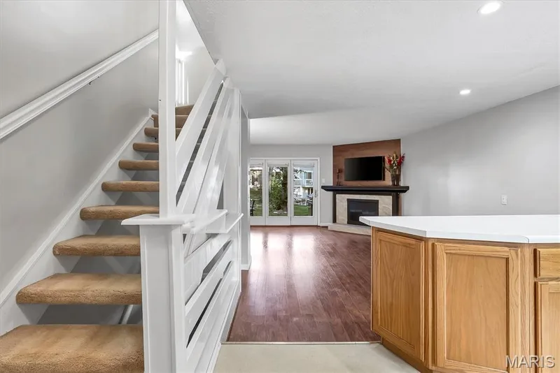 Carpeted staircase with white balusters — 43 Breezy Knoll Lane, Lake St. Louis, MO 63367