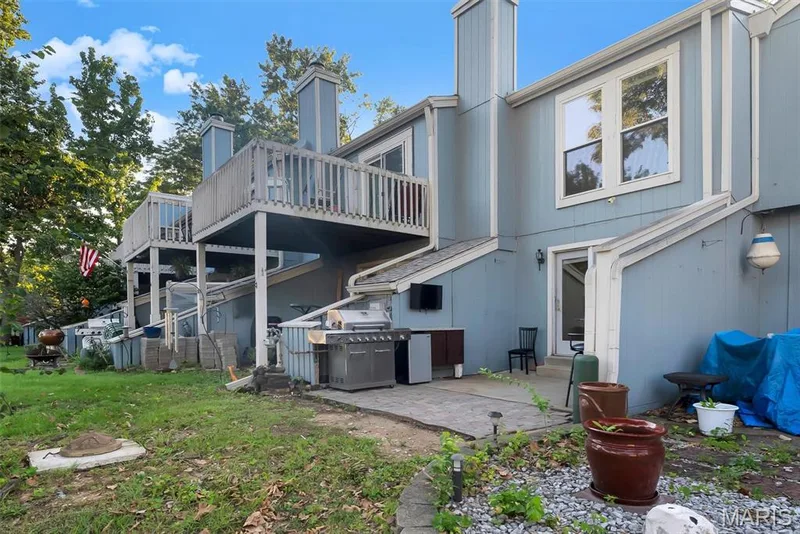 Rear exterior featuring light blue siding with white trim — 43 Breezy Knoll Lane, Lake St. Louis, MO 63367