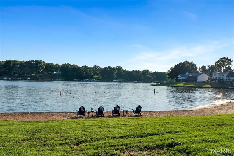 Lakeside property featuring a sandy beach, expansive waterfront, and a grassy area — 43 Breezy Knoll Lane, Lake St. Louis, MO 63367