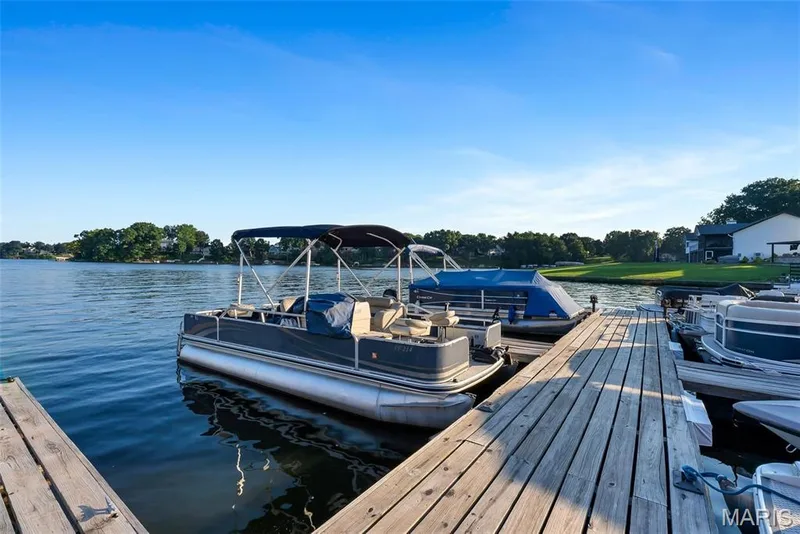 Lakefront setting with a wooden dock and direct water access — 43 Breezy Knoll Lane, Lake St. Louis, MO 63367
