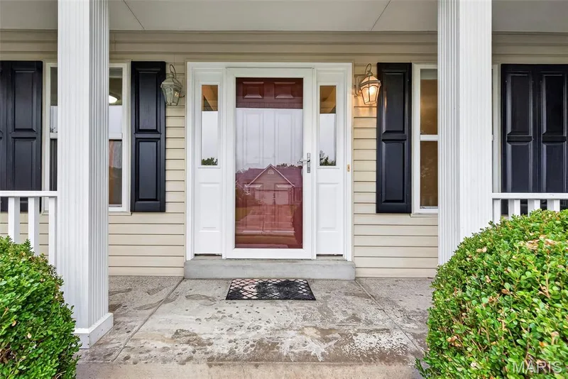 Welcoming entry with a wood-finish door, sidelights, and exterior lanterns — 4014 Treeshadow Drive, St Peters, MO 63376