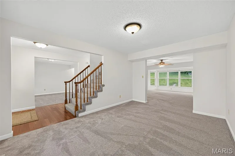 Central staircase with wood-finish handrail and carpeted treads — 4014 Treeshadow Drive, St Peters, MO 63376