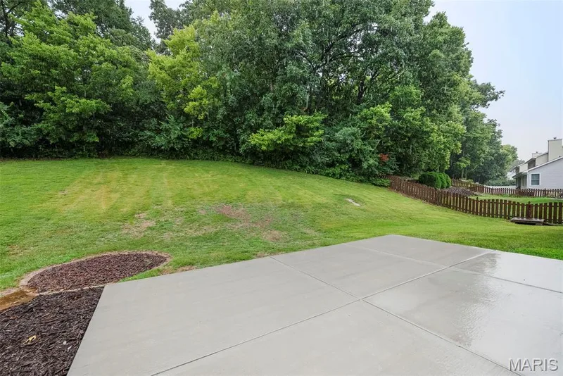 Expansive backyard featuring a new concrete patio, a manicured lawn, and mature trees — 4014 Treeshadow Drive, St Peters, MO 63376
