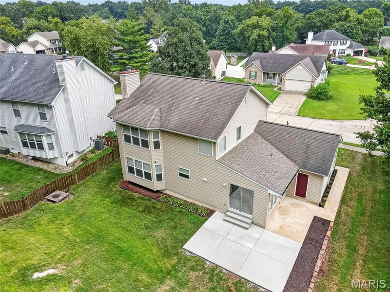 Expansive rear yard featuring a large concrete patio, an additional screened porch, and a dedicated mulch bed — 4014 Treeshadow Drive, St Peters, MO 63376