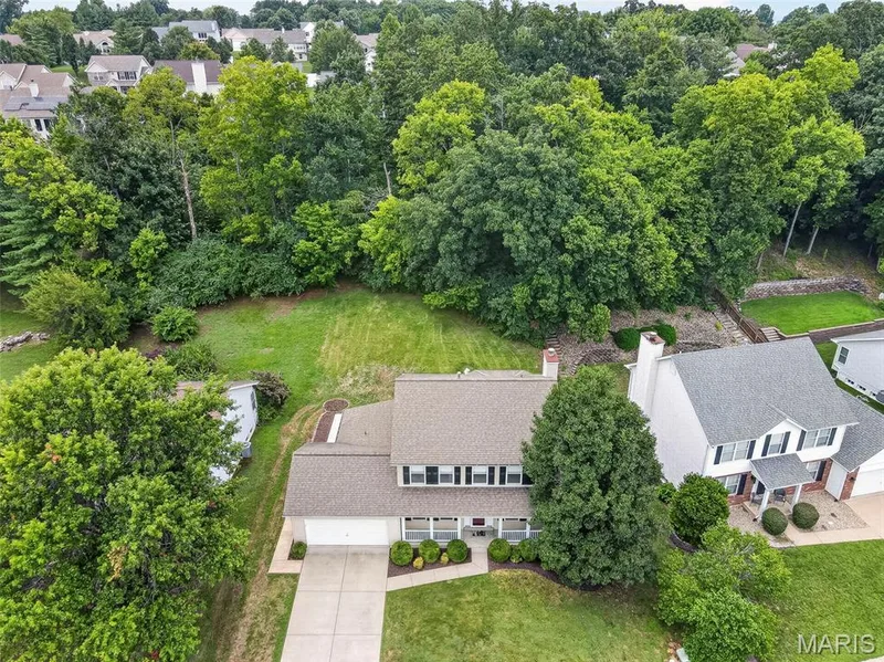 Two-story residence featuring a gray shingle roof, white siding, and dark window shutters — 4014 Treeshadow Drive, St Peters, MO 63376
