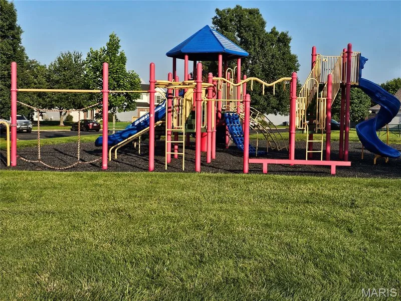 Expansive recreational area featuring a vibrant playground with multiple slides, climbing structures, and swing elements — 618 Homerun Drive, O'Fallon, MO 63366