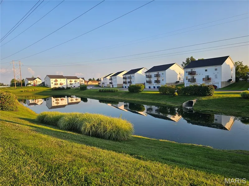 Community setting featuring a tranquil water element and manicured green spaces — 618 Homerun Drive, O'Fallon, MO 63366