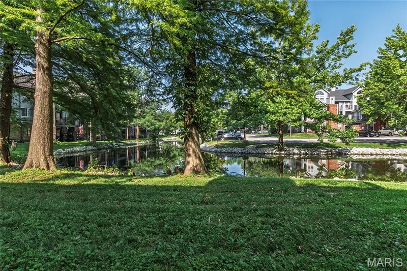 From the patio, you can enjoy the pond and quiet setting. — 1440 Heritage Landing #105, St Charles, MO 63303