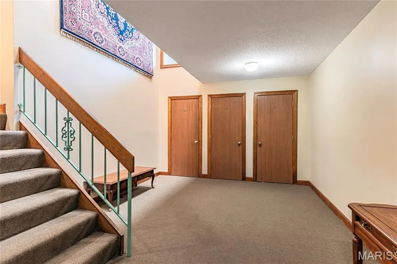 The unit's storage closet is located at the bottom of the stairs. — 1440 Heritage Landing #105, St Charles, MO 63303