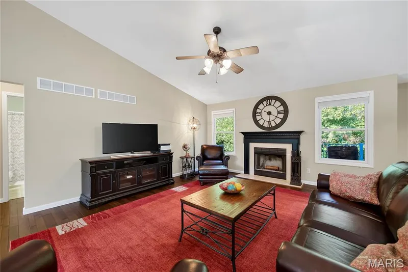 Great Room with Vaulted Ceilings, Wood Flooring and Wood Burning Fireplace with Marble Surround — 167 Rightfield Drive, O'Fallon, MO 63366