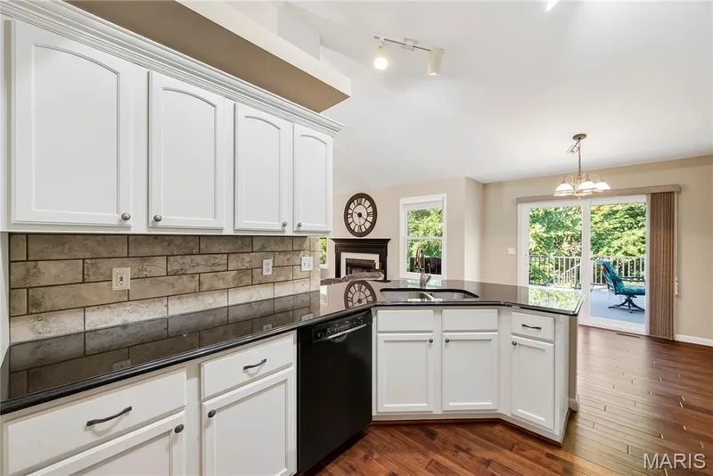 Granite Countertops, Tile Backsplash and White Cabinets with Crown Molding in Kitchen — 167 Rightfield Drive, O'Fallon, MO 63366