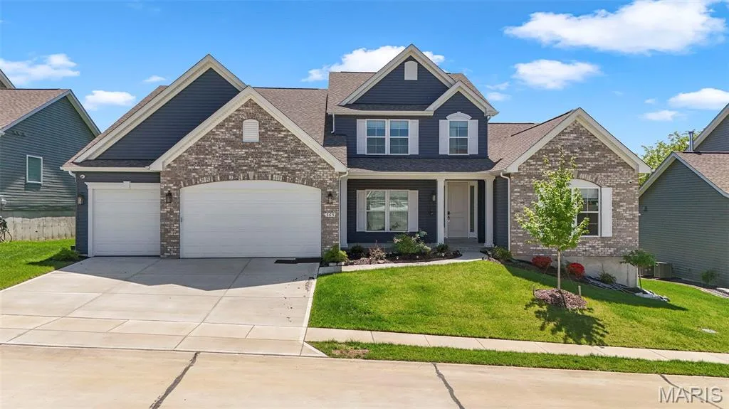 Two-story residence featuring a partial brick facade, horizontal siding, and a multi-gabled roofline — 365 Kreder Ridge Circle, St Charles, MO 63304