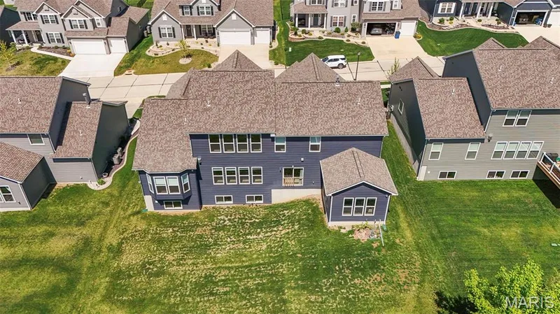 Contemporary residence featuring dark blue siding and a light brown shingle roof — 365 Kreder Ridge Circle, St Charles, MO 63304