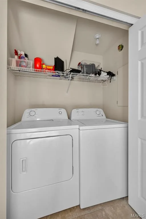 Dedicated laundry area featuring a white top-load washing machine and a white front-load dryer — 916 Carpathian Drive, Lake St. Louis, MO 63367