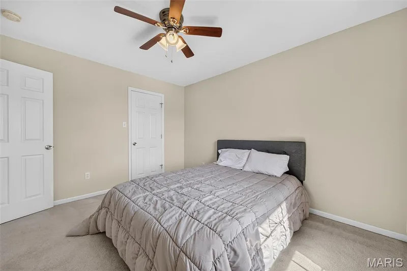 Neutral toned walls with white trim, light-colored carpet flooring, and a ceiling fan with light fixture — 916 Carpathian Drive, Lake St. Louis, MO 63367