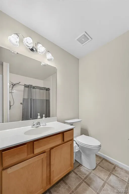 2nd floor Bathroom featuring a light wood-finish vanity with a white countertop and integrated sink, a chrome faucet, and a large wall-mounted mirror — 916 Carpathian Drive, Lake St. Louis, MO 63367
