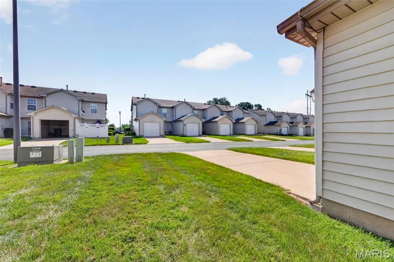 Expansive green lawn bordering concrete pavement — 916 Carpathian Drive, Lake St. Louis, MO 63367