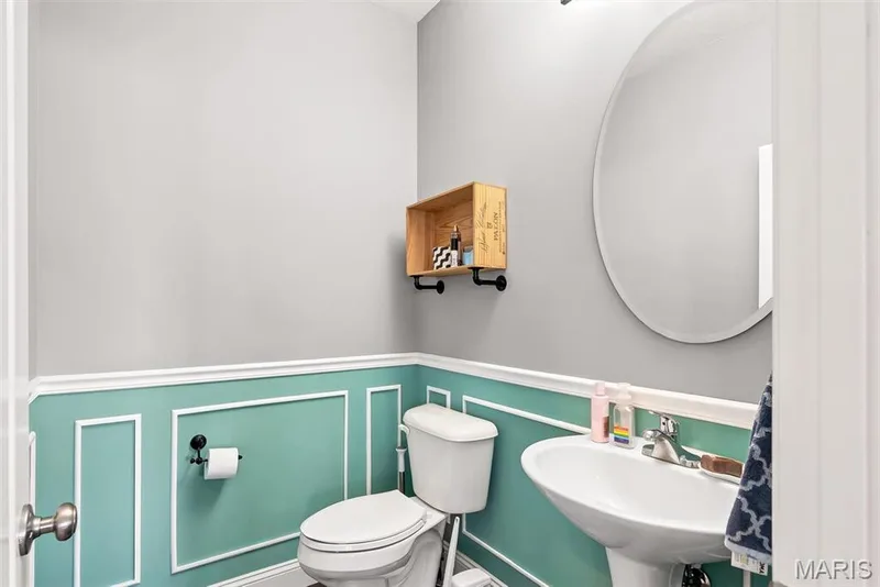 Charming powder room featuring a two-tone wainscot design in soft sage green and crisp white trim, creating classic visual interest — 225 Thorn Brook Drive, O'Fallon, MO 63366