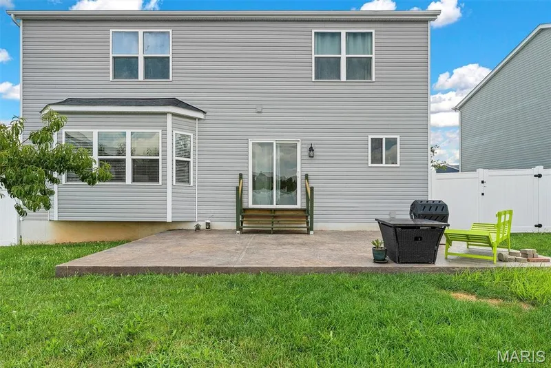 Rear exterior featuring gray vinyl siding, multiple windows, and a bay window — 225 Thorn Brook Drive, O'Fallon, MO 63366