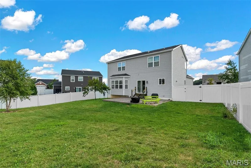 Expansive rear yard featuring a large grass area, full vinyl fencing, and mature trees — 225 Thorn Brook Drive, O'Fallon, MO 63366