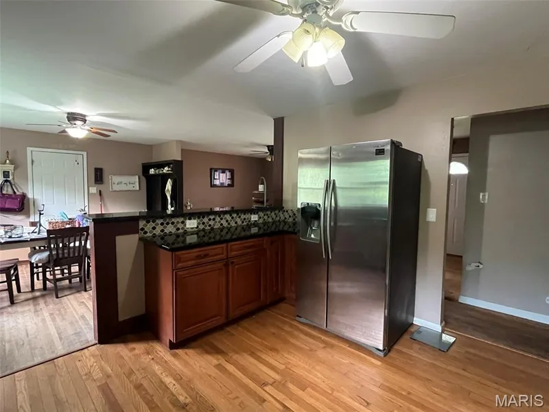 Custom Cabinets, Granite, Stainless Steele appliances, Hardwood floors, designer tile backsplash, opens to dining room — 2701 Headland Drive, St Charles, MO 63301
