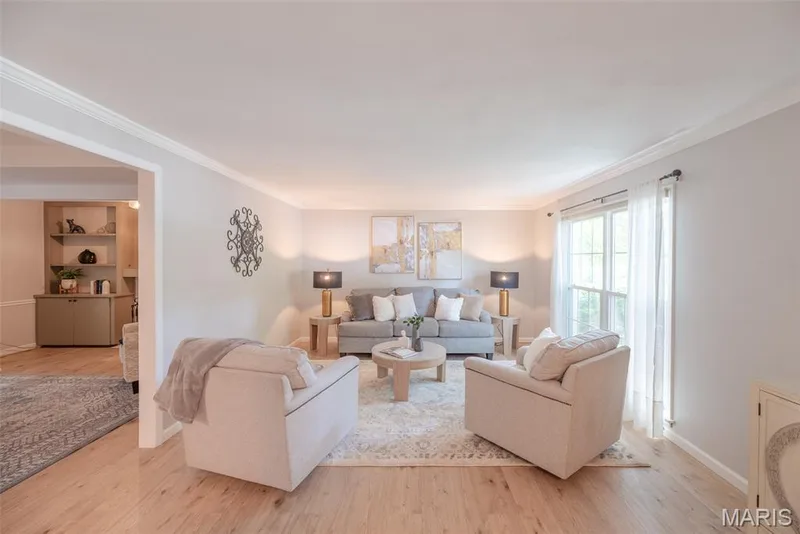 Bright, open living space anchored by wood-finish flooring throughout, featuring abundant natural light from multiple windows and glass doors — 1526 Candish Lane, Chesterfield, MO 63017