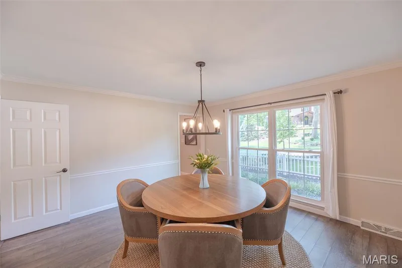 Wood-finish flooring with a multi-pane window, crown molding, and chair rail detailing — 1526 Candish Lane, Chesterfield, MO 63017