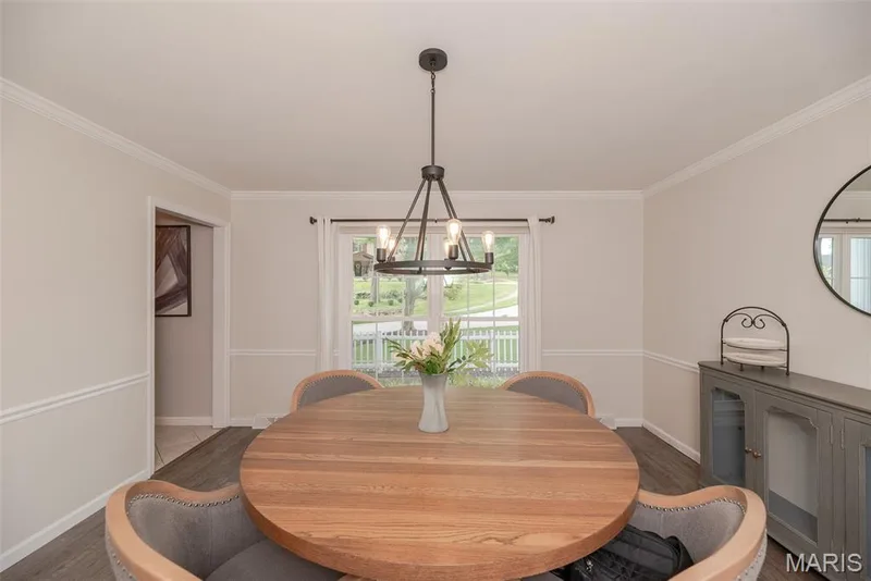 Crown molding and chair rail detailing, wood-finish flooring, and a modern chandelier — 1526 Candish Lane, Chesterfield, MO 63017