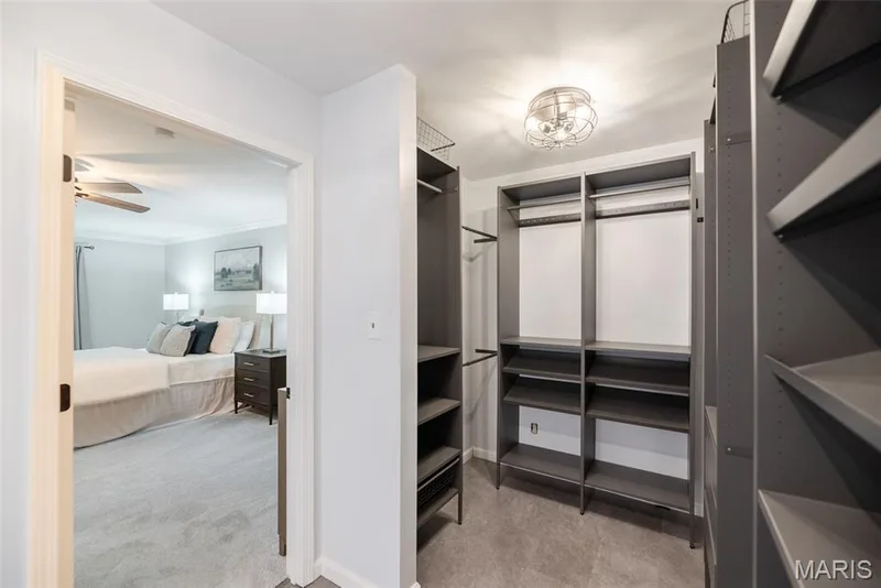 Walk-in closet featuring extensive built-in shelving and hanging rods — 1526 Candish Lane, Chesterfield, MO 63017
