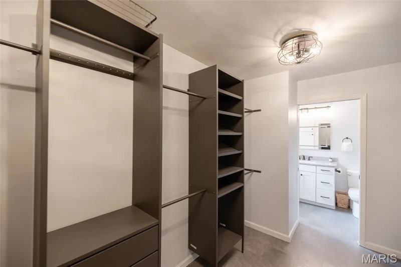 Custom closet organization system with ample hanging rods, integrated shelving, and drawers — 1526 Candish Lane, Chesterfield, MO 63017