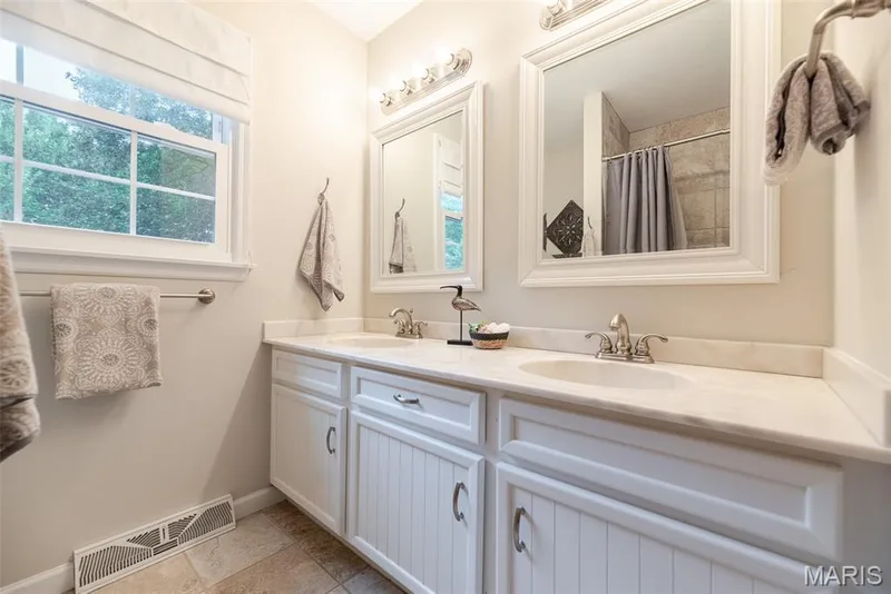 Double vanity with integrated sinks, white cabinetry, and brushed nickel hardware — 1526 Candish Lane, Chesterfield, MO 63017