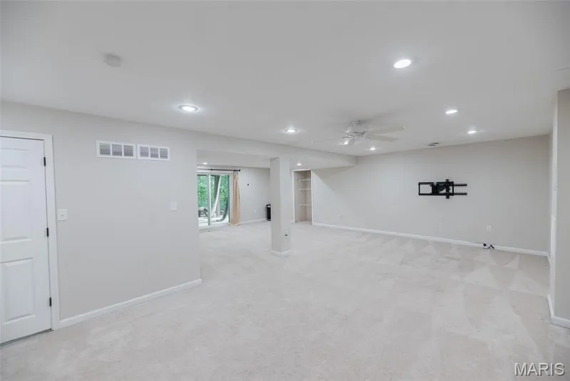 Expansive carpeted room featuring recessed lighting, a ceiling fan, and sliding glass doors — 1526 Candish Lane, Chesterfield, MO 63017