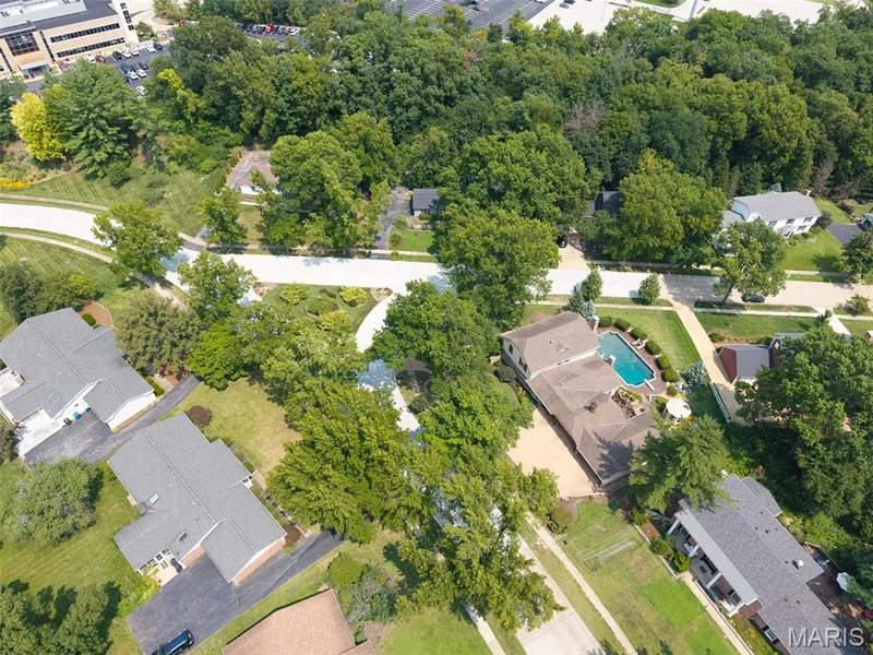 Residential property featuring a swimming pool, mature trees, and a paved driveway — 1526 Candish Lane, Chesterfield, MO 63017