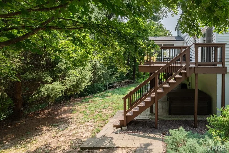 Two-level wood deck with railings, exterior staircase, and ground-level patio pavers — 1526 Candish Lane, Chesterfield, MO 63017