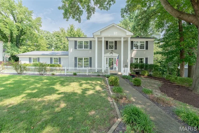 Colonial-style exterior with a portico, white columns, gray siding, and dark window shutters — 1526 Candish Lane, Chesterfield, MO 63017