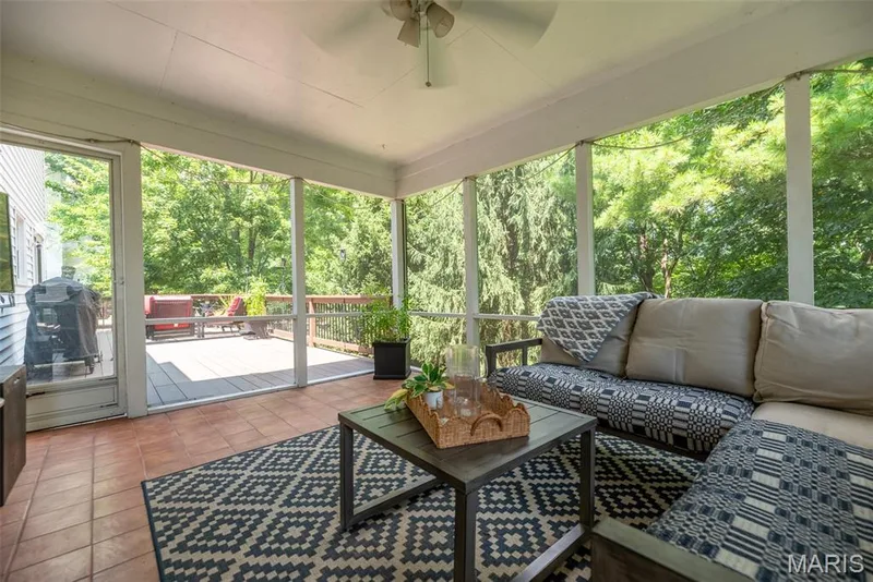 Screened porch featuring a ceiling fan, terracotta tile flooring, and direct access to an exterior deck — 1526 Candish Lane, Chesterfield, MO 63017