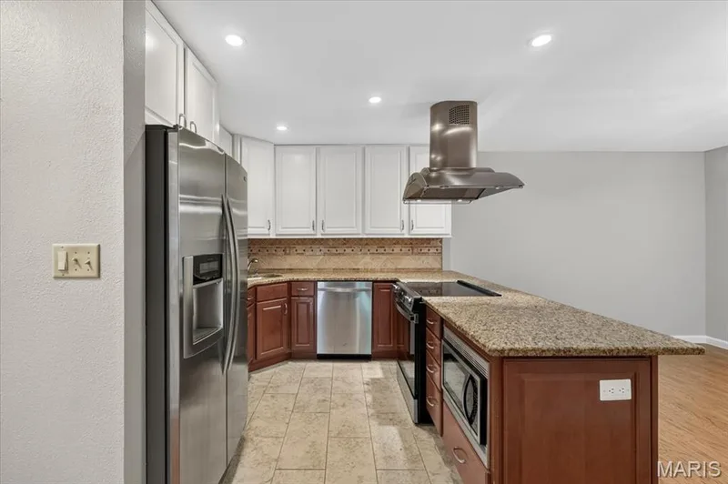 The kitchen has hard surface counters and a tile/stone backsplash. — 1380 Heritage Landing #202, St Charles, MO 63303