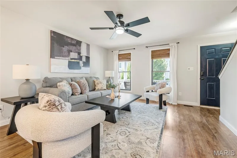 Living area featuring wood-finish flooring, light grey walls, and a ceiling fan with integrated lighting — 3429 Sublette Street, St Charles, MO 63301