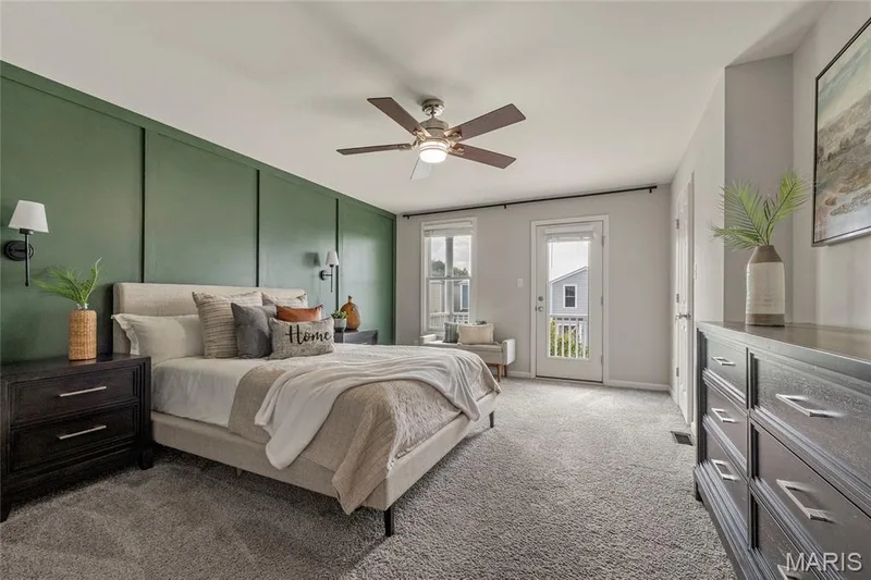 Spacious bedroom featuring an accent wall with vertical paneling, two windows, and a glass-paneled door — 3429 Sublette Street, St Charles, MO 63301