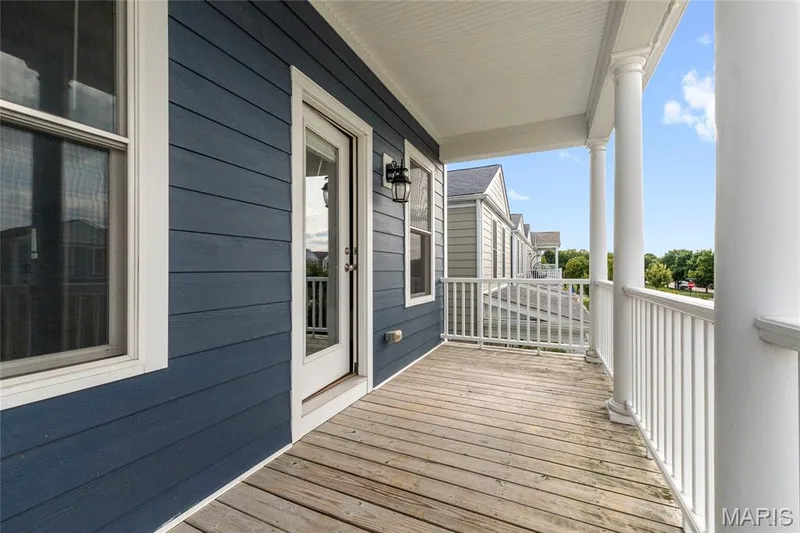 Covered front porch featuring wood-finish decking, white balusters, and classic white columns — 3429 Sublette Street, St Charles, MO 63301