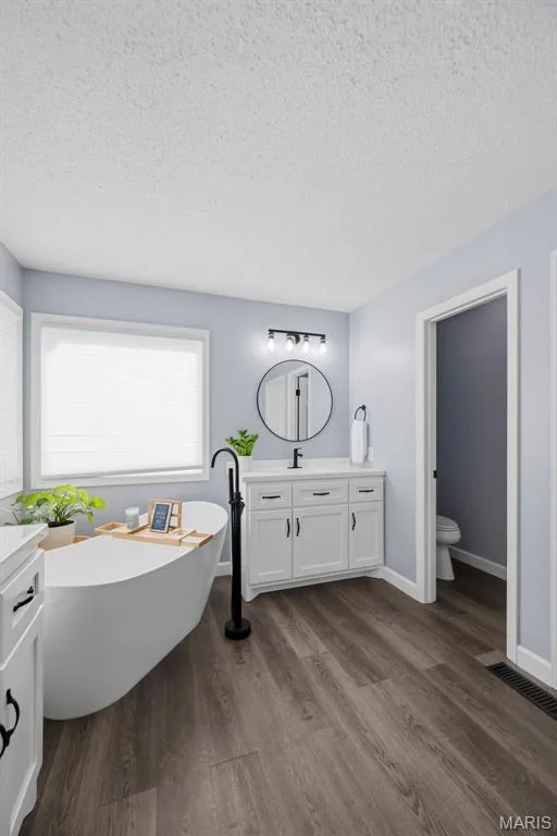 Updated primary bath featuring a freestanding soaking tub and modern finishes. — 2 Emmons Court #1294, O'Fallon, MO 63368