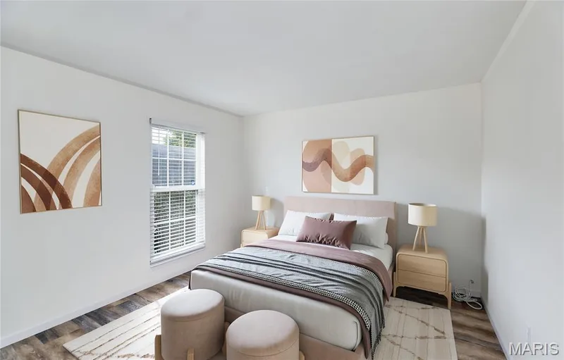 Bedroom with crisp white walls, a window with horizontal blinds, wood-finish flooring, and a light-colored ceiling — 146 Old Buggy Court #A, St Charles, MO 63304